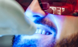 Smiling man getting in-office teeth whitening in San Antonio