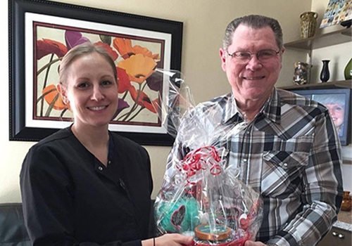 Dental team member giving patient a gift basket