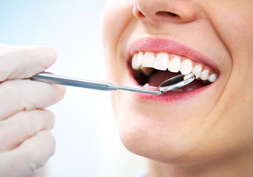 Dentist examining patient's tooth-colored filling