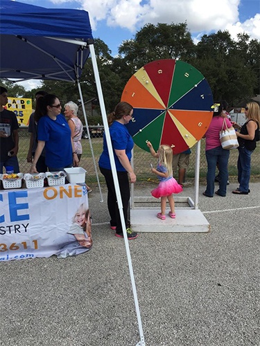 Child using prize wheel at community event