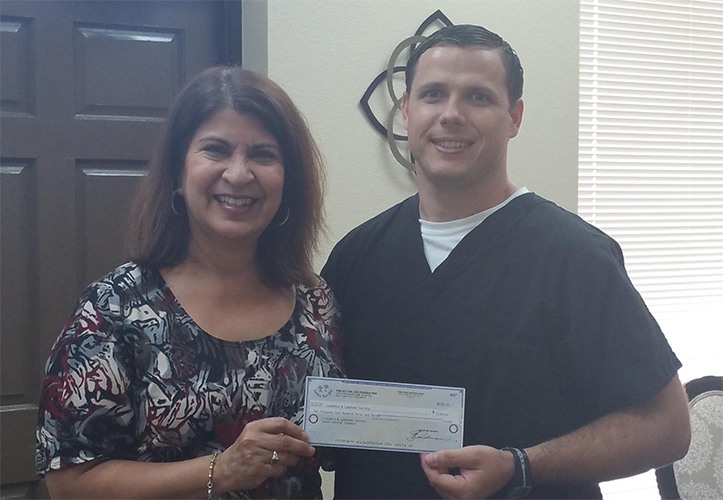 Dentist giving community organization a donation