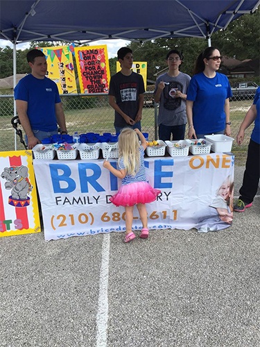 Dentist and dental team members at table for community event