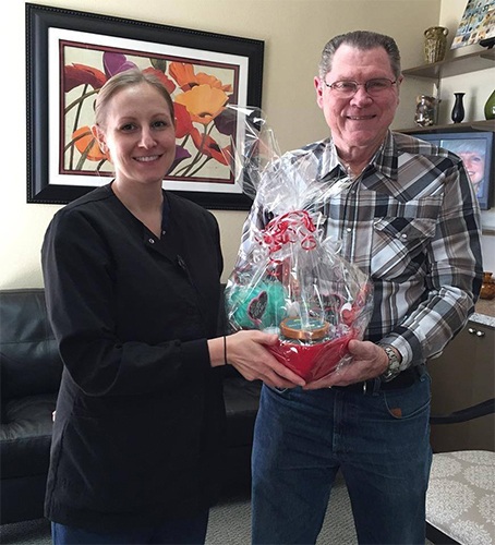 Dental team member giving patient a gift basket