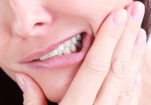 Patient in need of tooth extraction holding jaw