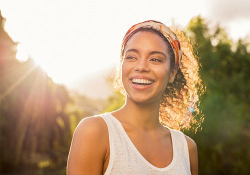 smiling woman walking through a park