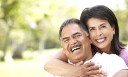 Couple with dental implants in San Antonio smiling outside