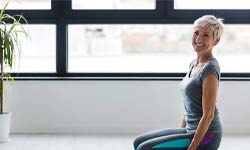 Woman with dental implants in San Antonio practicing yoga