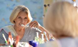 Woman brushing her teeth after dental implant surgery in San Antonio