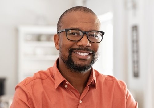 Smiling man with dental implants in San Antonio and glasses