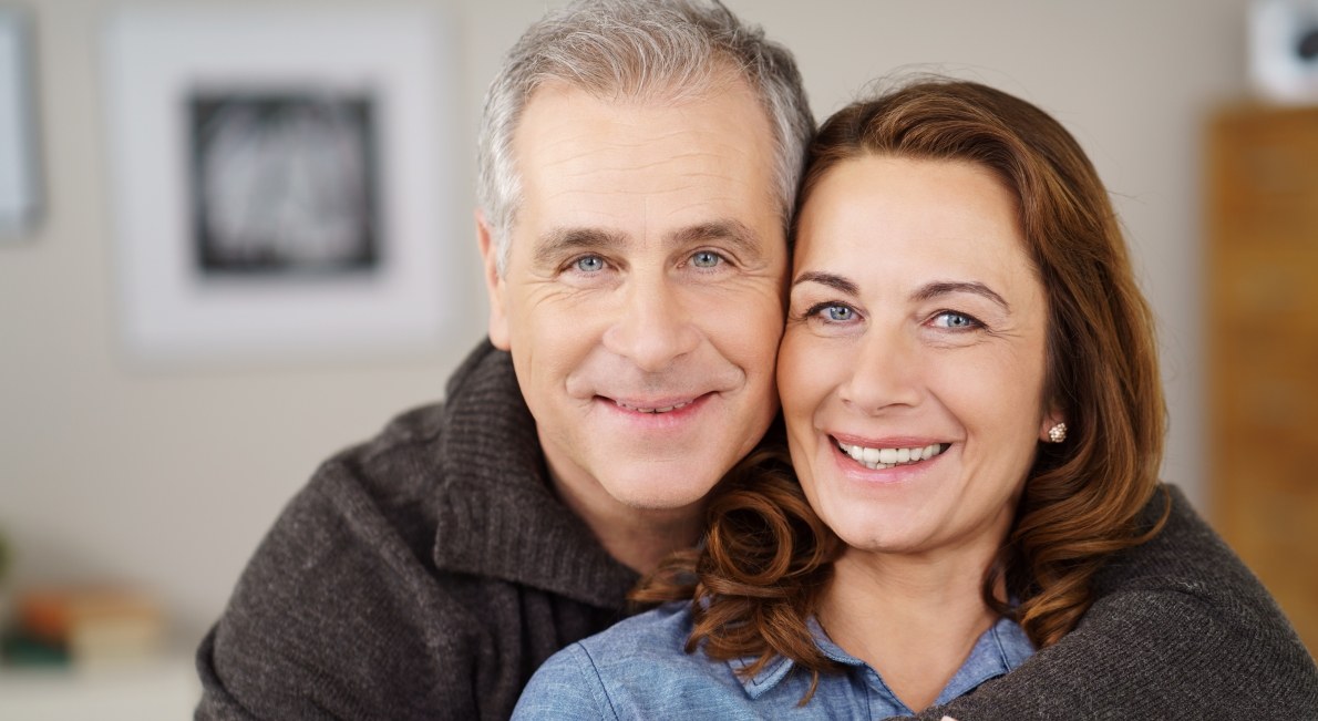 Older couple smiling and holding each other