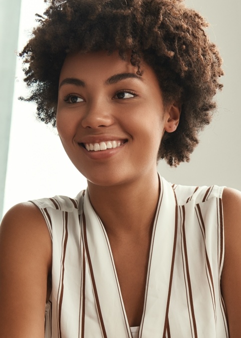 Woman in white striped sleeveless blouse smiling