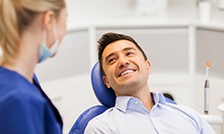 Man smiling while looking at dentist in treatment room