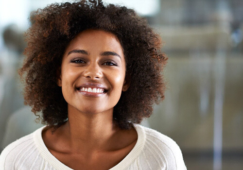 close-up of a woman in a sweater smiling