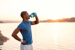 man drinking water after exercising