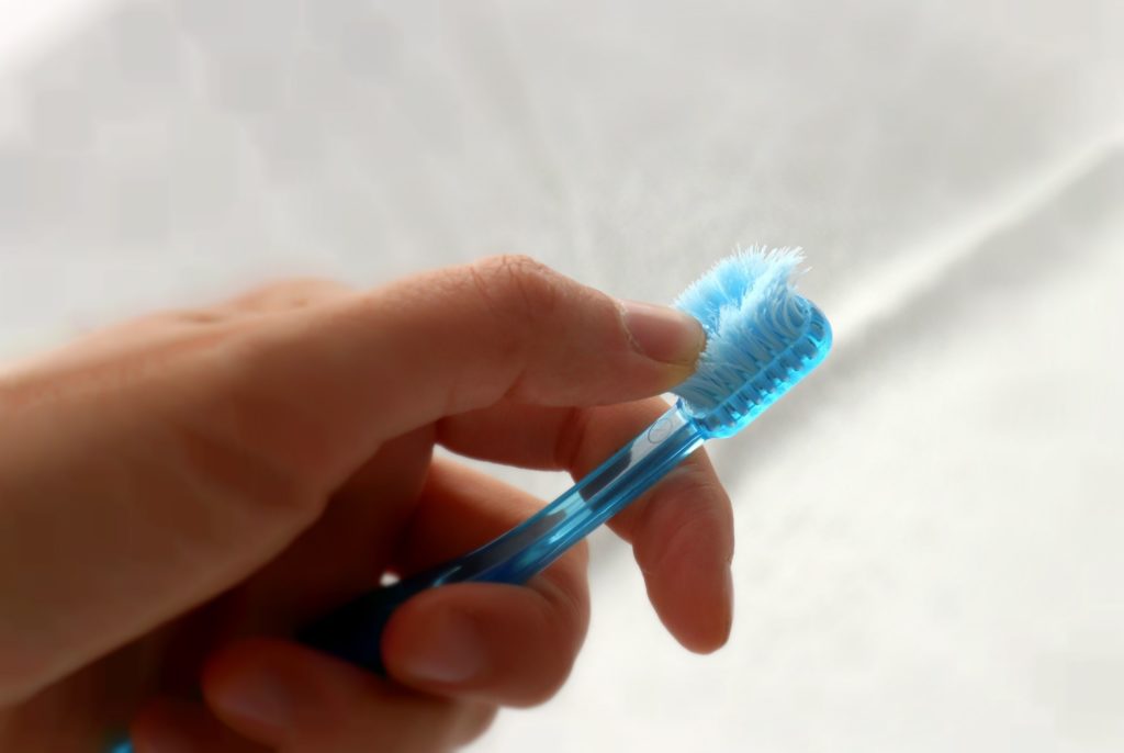 Patient checking frayed toothbrush