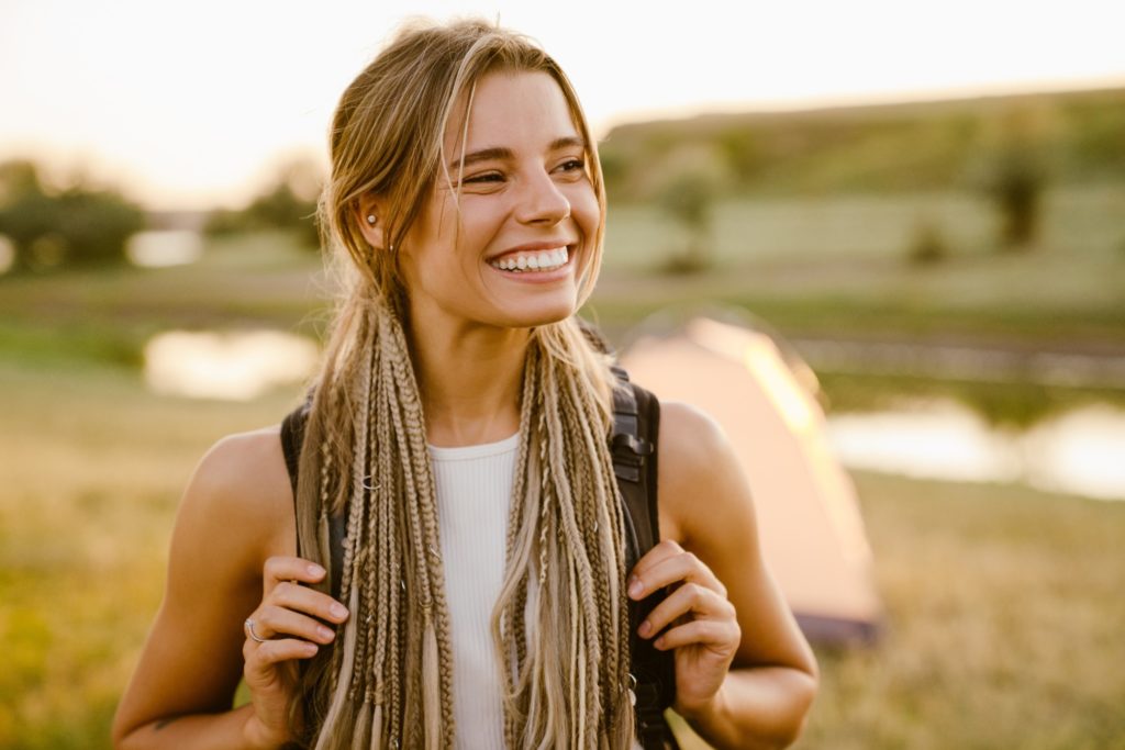 Woman smiling while backpacking through countryside