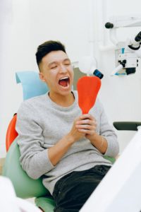 Man in dentist’s chair looking in a mirror